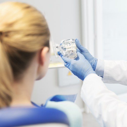 Dentist and patient looking at smile model during preventive dentistry visit