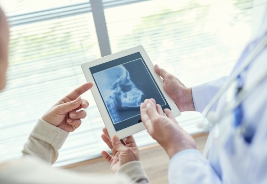 Dentist and patient looking at digital x-rays during dental checkups and teeth cleanings