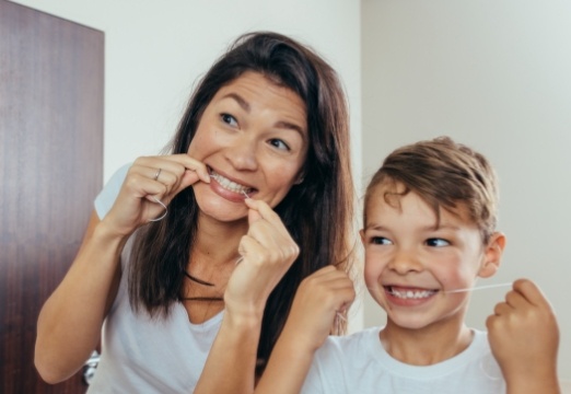 Mother and child flossing teeth to prevent dental emergencies