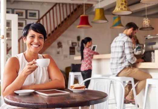 Woman drinking coffee after tooth replacement with dental implants