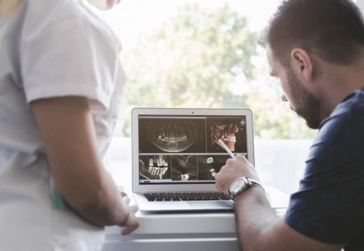 Dentist and patient reviewing the cost of dental implant treatment plan