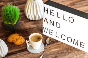 “Hello and Welcome” sign next to coffee and cookies